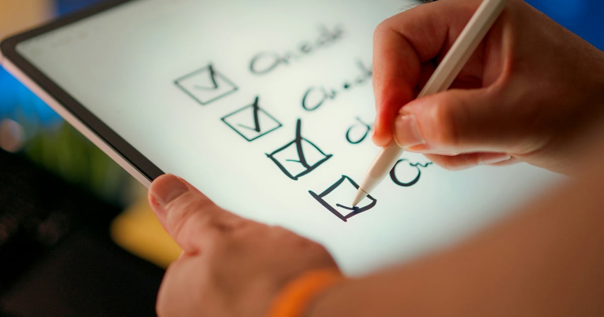 A hand with a stylus ticking the fourth box of a checklist written on a tablet screen